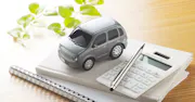 A small toy car and a calculator on top of two notebooks