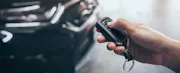 Hand presses unlock on the car remote control.